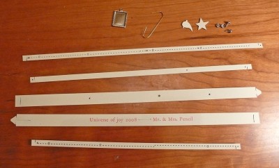 The Contents of the kit: two large strips for the outer rings, three inner orbits, a comet, a star, four brads, a hanging frame for a solar body and a hook